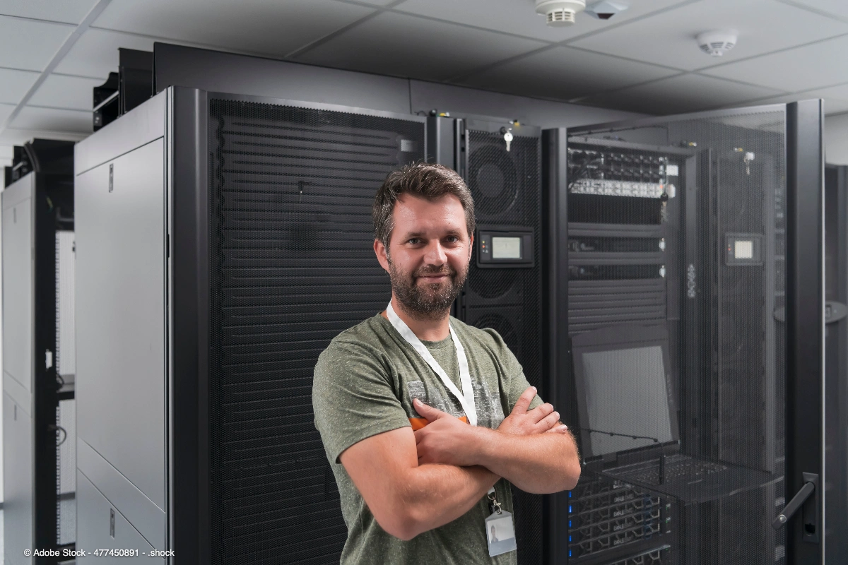 Ein IT-Techniker steht vor großen Serverschränken in einem Rechenzentrum und veranschaulicht, wie sich ein Serverraum kühlen lässt.